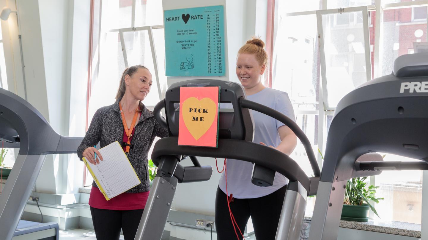 A woman shows another women how to do a heart test on a treadmill