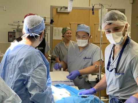 A team of people in scrubs complete a simulation in the operating room