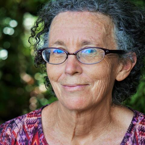 An image of an older woman wearing glasses smiling at the camera